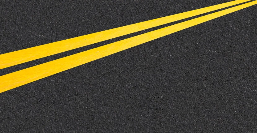 Yellow road markings on dark asphalt